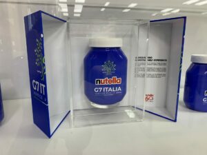 L'immagine dell'ulivo, simbolo del G7 a presidenza italiana, si staglia su una confezione azzurra...