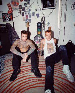 Chi è questo eccentrico personaggio dalle rime taglienti e dall'abbigliamento colorato che sta...