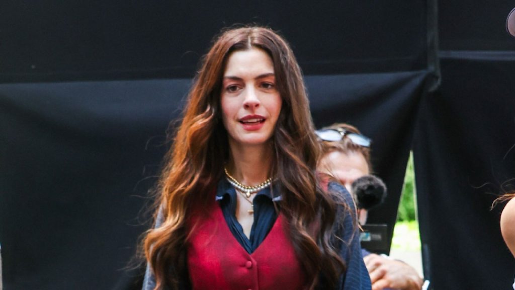 Anne Hathaway svela il look perfetto: stivali alti e maxi dress per la stagione.