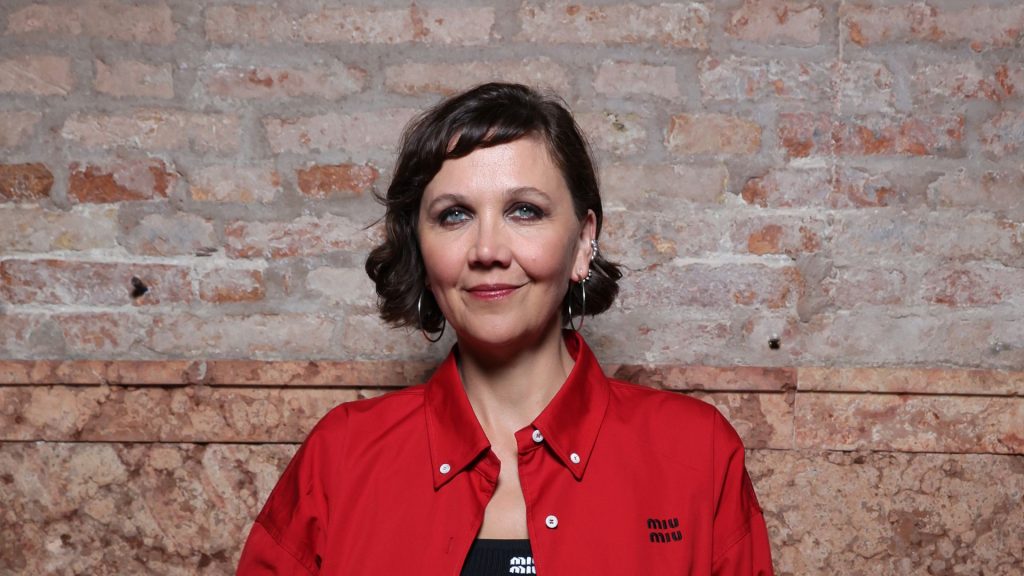 Maggie Gyllenhaal sfila al Festival di Venezia in un audace completo rosso Miu Miu.