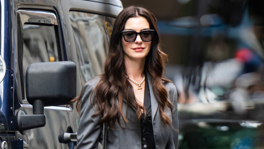 Anne Hathaway dimostra che gli stivali da cowboy sono il trend chic per il tailoring.