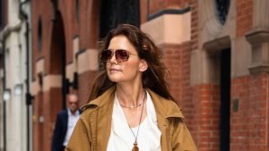 Katie Holmes’ borsa bordeaux: un tocco di colore per un trench beige classico.