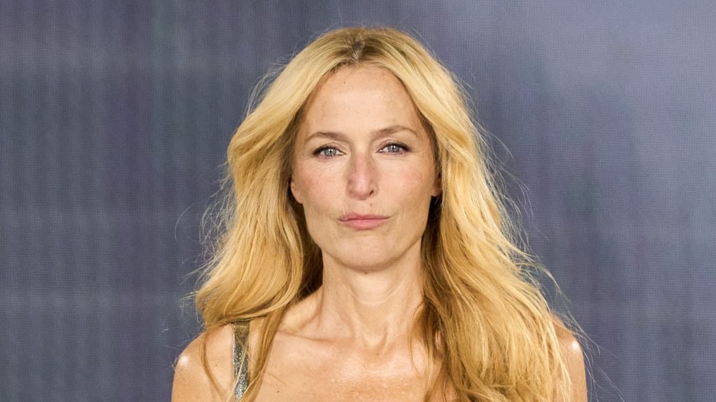 Gillian Anderson svela l’eleganza dell’autunno con un abito metallico e stampe a catena.