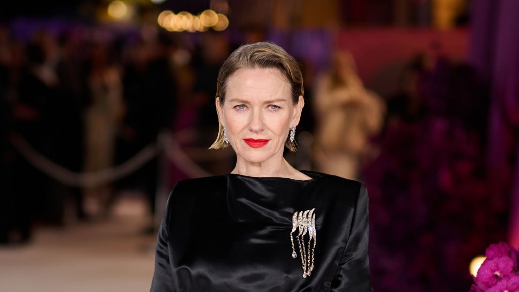 Naomi Watts brilla all’premiere di ‘All’s Fair’ con un elegante abito nero e un brillante brooch.