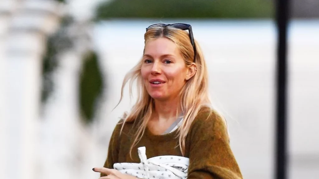 Sienna Miller: il look invernale perfetto con jeans a gamba svasata e clogs Birkenstock.