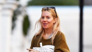 Sienna Miller: il look invernale perfetto con jeans a gamba svasata e clogs Birkenstock.
