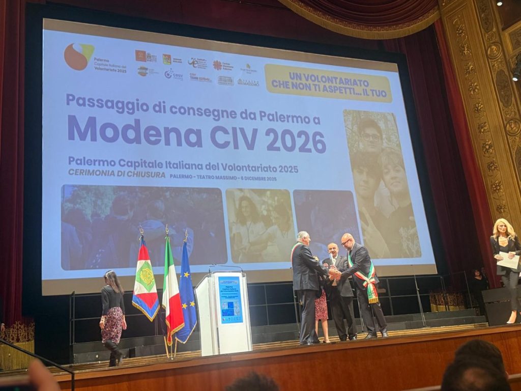 Modena premiata come Capitale italiana del Volontariato 2026, il sindaco riceve la targa.