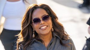 Oprah Winfrey sfoggia eleganti pantaloni camel e blusa cerulea: tendenze moda 2026.