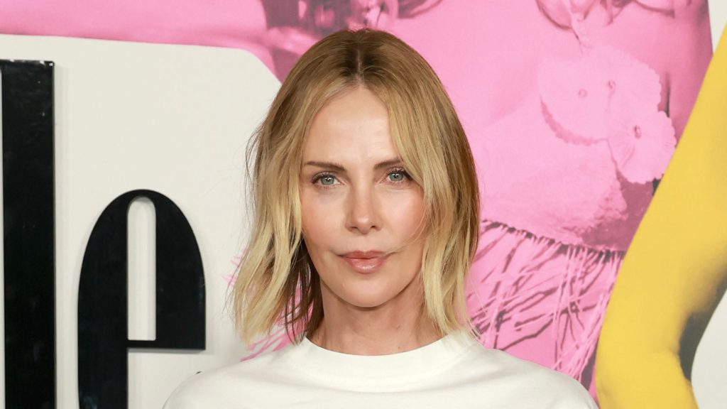 Charlize Theron rivisita il look anni ’90 con pantaloni ampi a righe e T-shirt over size.