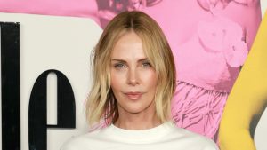 Charlize Theron rivisita il look anni ’90 con pantaloni ampi a righe e T-shirt over size.