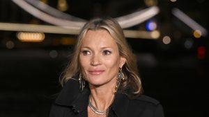 Kate Moss incanta al fashion show di Burberry con un LBD satinato e trench nero.
