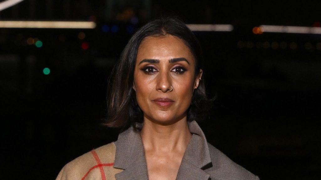 Anita Rani impreziosisce il suo suit oversize con una sciarpa Burberry, tendenza del momento.