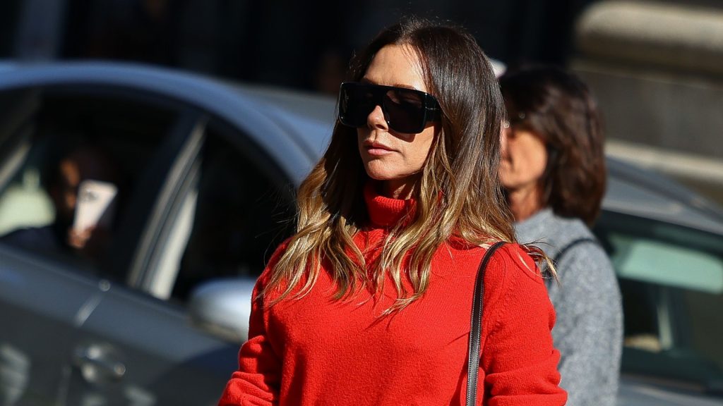 Victoria Beckham: il perfetto abbinamento tra dolcevita rosso e pantaloni camel a campana.