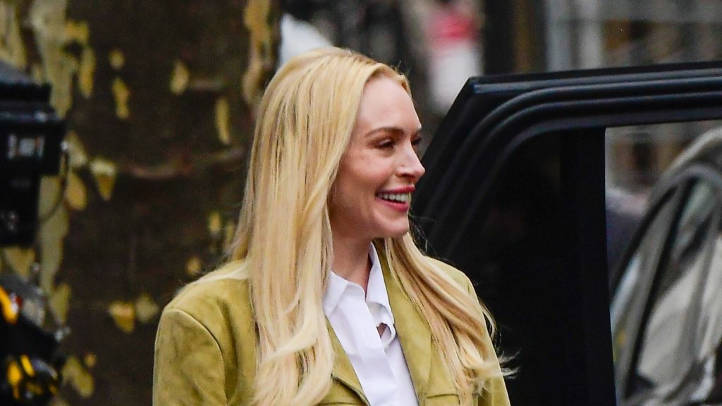 Lindsay Lohan incanta con giacca scamosciata e jeans dritti: un abbinamento di moda perfetto.
