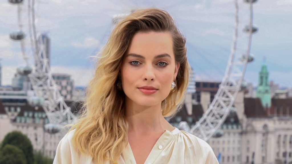 Il look di Margot Robbie: giallo burro e jeans bianchi, un abbinamento senza tempo.