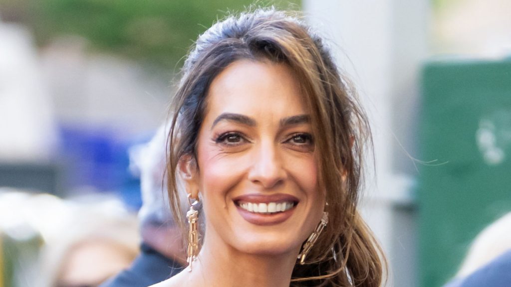 Amal Clooney sfida il giallo burro con un audace mini vestito magenta.