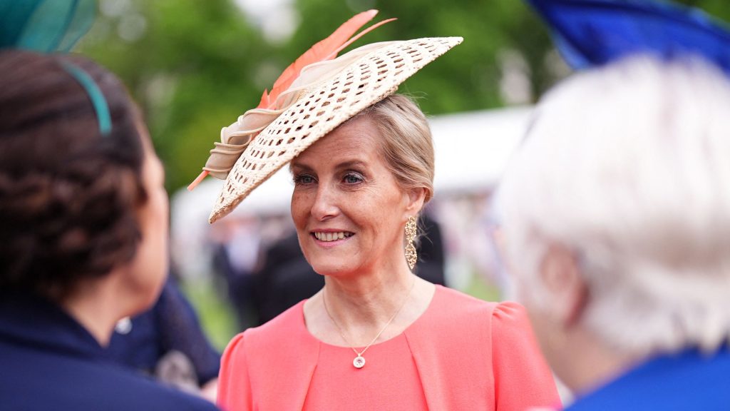 Accessori in rafia: il tocco chic di Duchessa Sophie al giardino con un midi dress.