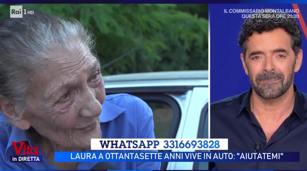 Alberto Matano sorprende Laura, 87enne senza casa, regalando una notte in hotel su Rai 1.