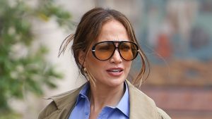 Jennifer Lopez incarna l’eleganza parigina con jeans a gamba larga e camicia blu pervinca.
