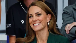 Kate Middleton affascina con un look autunnale: blazer verde, gilet a righe e gonna plissettata.