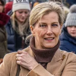 Look autunnale: maglione marrone, jeans khaki e stivali alti per giornate fresche e soleggiate.