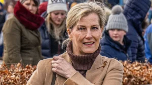 Look autunnale: maglione marrone, jeans khaki e stivali alti per giornate fresche e soleggiate.